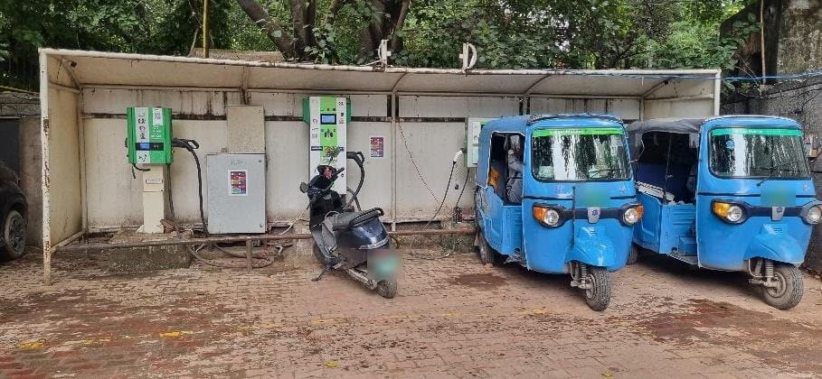 EVIT chargers at a municipal parking station in Delhi, charging e-rickshaws and a scooter